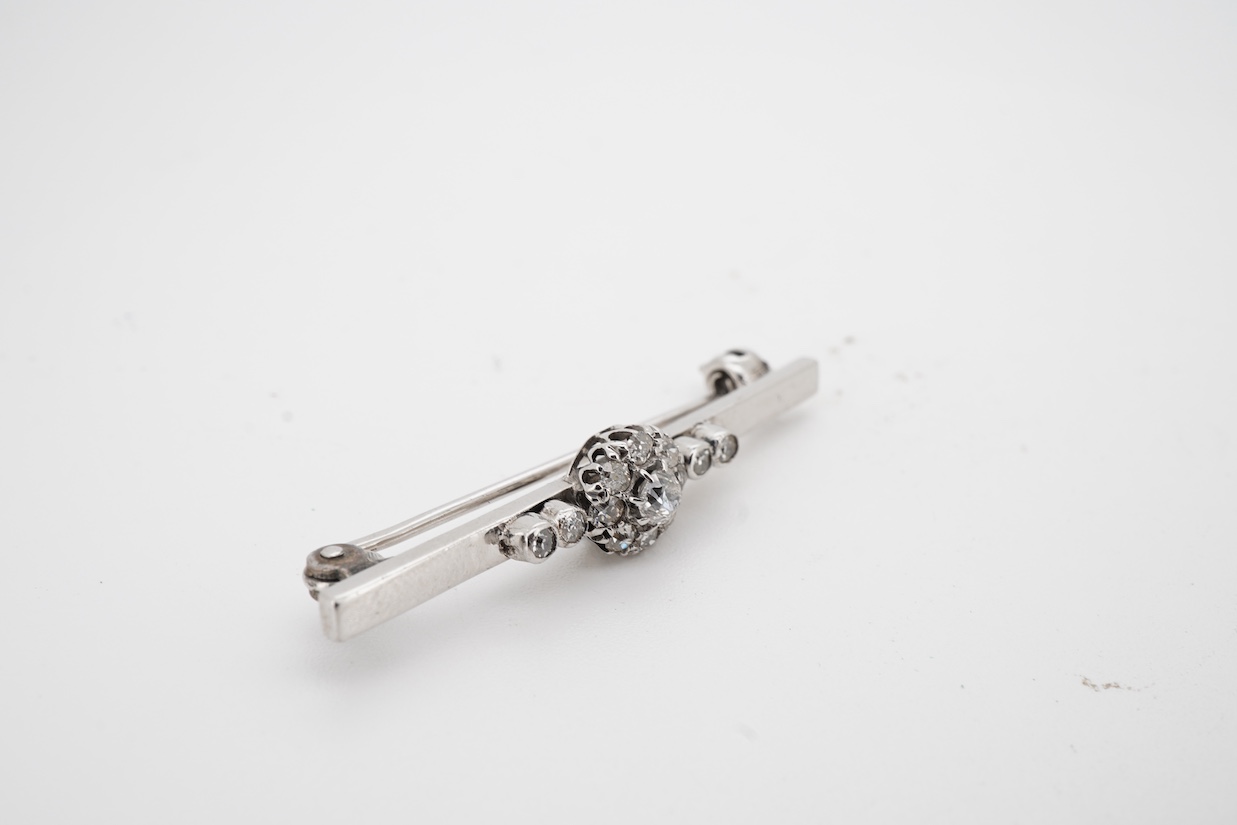 A white metal (stamped 9ct W.G.), and diamond cluster set bar brooch, 38mm.